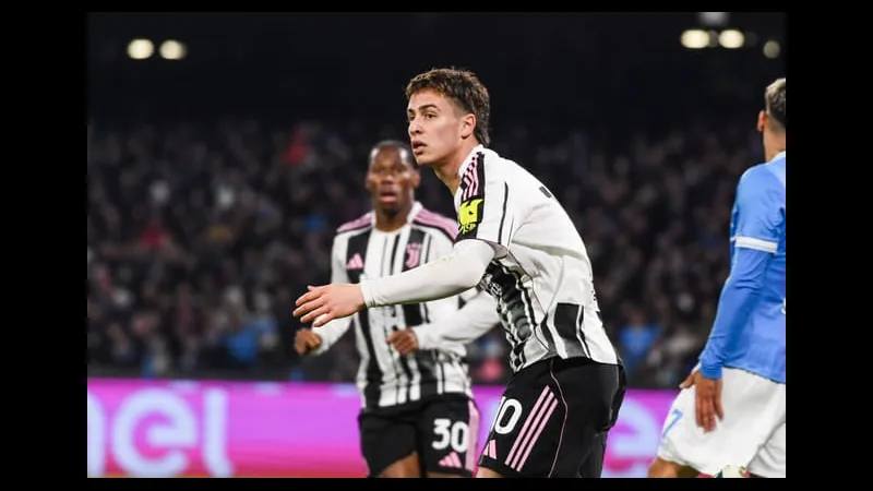 Cầu thủ Juventus với chiếc áo số 10 đang chạy với bóng trước sự áp sát của cầu thủ đối…